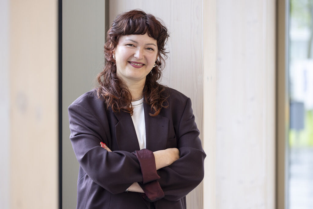 Modernes Business-Portrait einer Doktorandin am Fenster mit Licht- und Spiegelungen